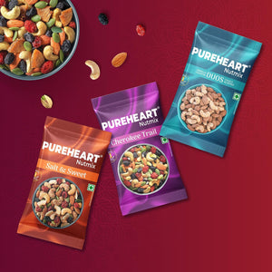 PUREHEART Rakhi Gift Hamper- Vanilla Cashew & Choco Almonds, Cherokee Trail Mix, Sweet & Salt Nutmix (25 g Each) with Chocolate and Floral Rakhi for Brother, Gift Card, Pooja Rice, Kumkum - Crunchy Dry Fruits and Nuts