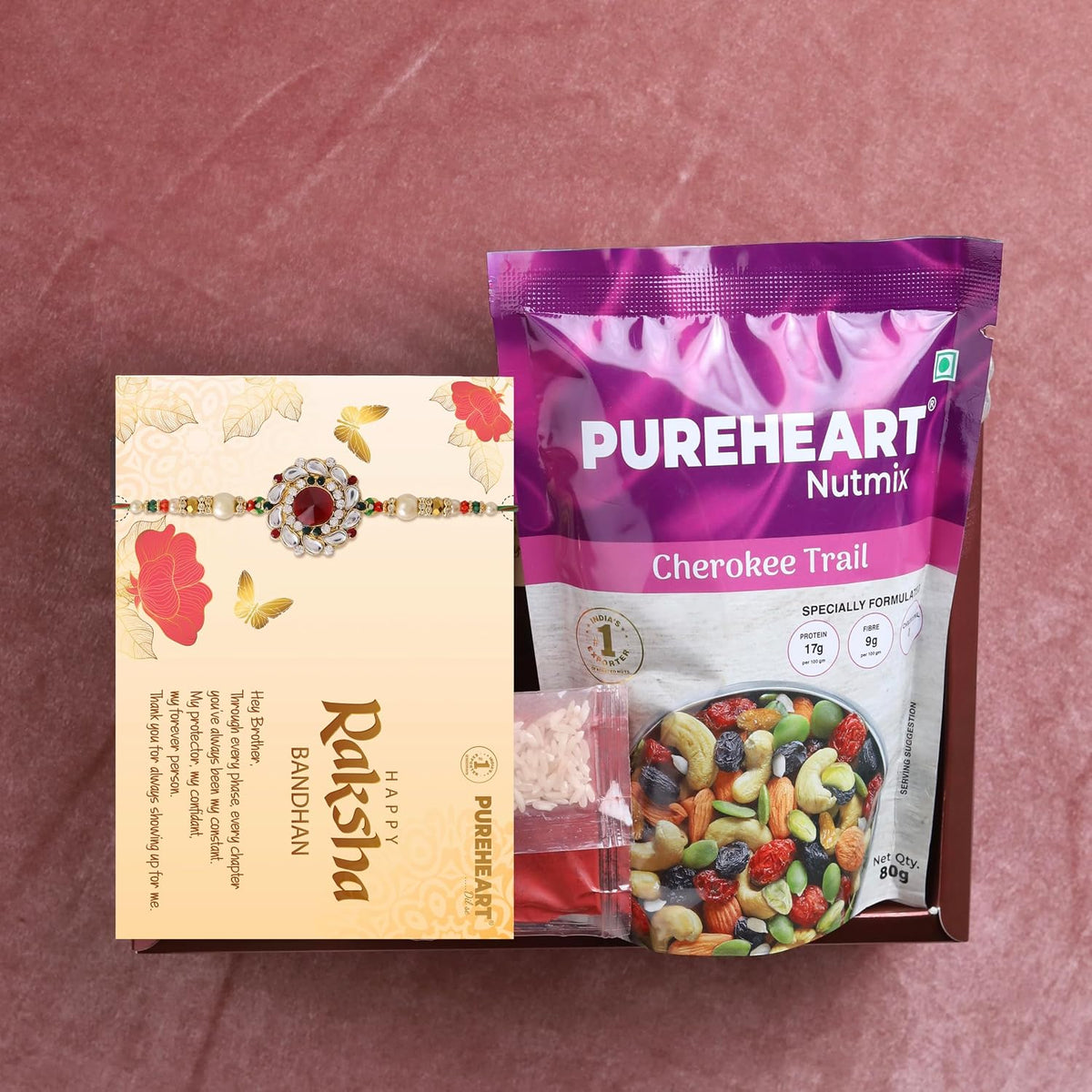 PUREHEART Rakhi Gift Hamper- Cherokee Trail Mix (80g) and Chocolates with Floral Rakhi for Brother, Gift Card, Pooja Rice, Kumkum - Dry Fruits and Nuts Gift