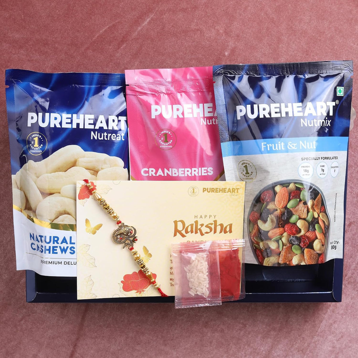 PUREHEART Rakhi Gift Hamper- Natural Cashews, Fruit & Nut Nutmix and Cranberries(80g, each) with Designer Rakhi for Brother, Gift Card, Pooja Rice, Kumkum - Crunchy Dry Fruits and Nuts